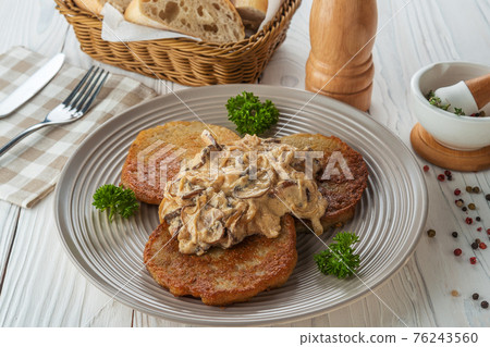 Potato pancakes with sauce and fried onions with parsley Potato pancakes with sauce and fried onions with parsley 76243560