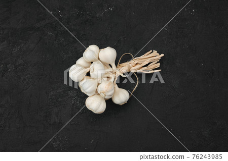Overhead view of bunch of garlic on dark background 76243985