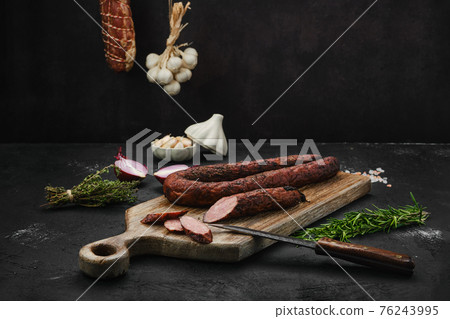 Smoked pork sausage with spices on cutting board Smoked pork sausage with spices on cutting board 76243995