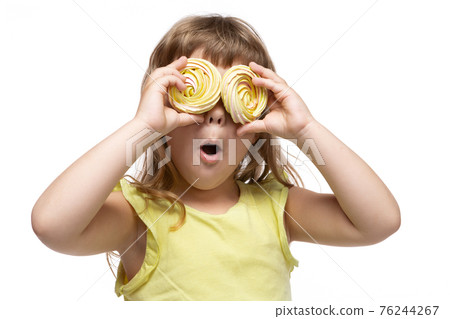 happy little girl in yellow clothes, from two big candies made eyes, emotions and gestures, surprise, on a white background 76244267