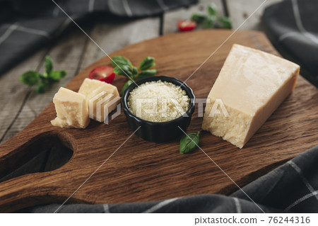 Italian cuisine concept. Parmesan Cheese chunks, cherry tomatos, basil leaves 76244316