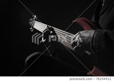 Male musician playing six-string fretless bass guitar Male musician playing six-string fretless bass guitar 76244412