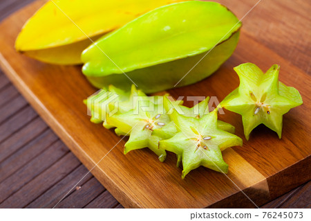 Cut fresh juicy cannon fruits on wooden background 76245073