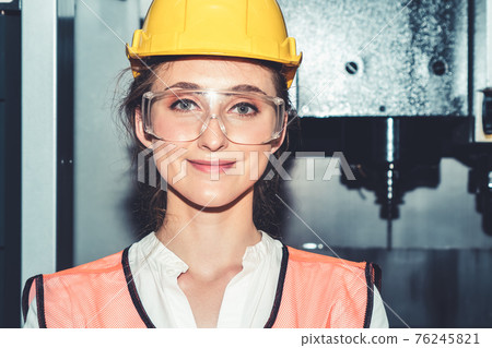 Young woman factory worker close up portrait in manufacturing job factory Young woman factory worker close up portrait in manufacturing job factory 76245821