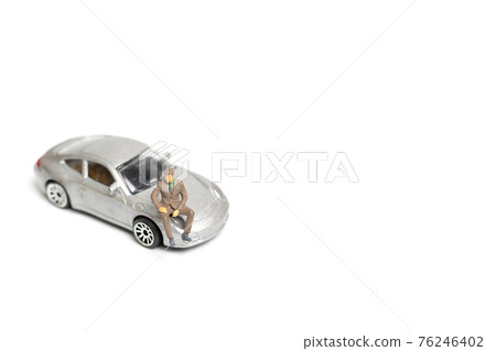 Miniature people business man sitting on a car 76246402