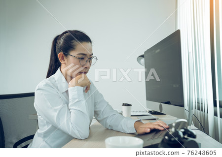 Asian female software developer is worried about analyzing code-based systems at his office. Asian female software developer is worried about analyzing code-based systems at his office. 76248605