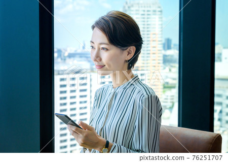 操作辦公室裡的智能手機的女商人(休閒) 操作辦公室裡的智能手機的女商人(休閒) 76251707