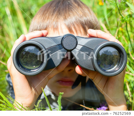Child looking through binoculars Child looking through binoculars 76252569