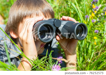 Child looking through binoculars Child looking through binoculars 76252573