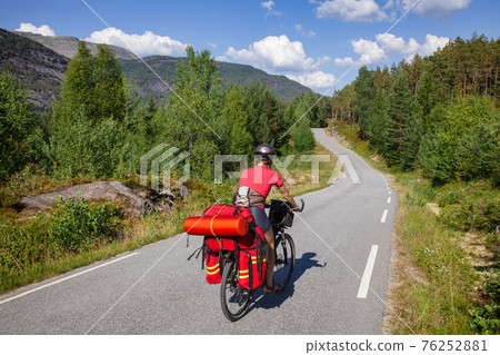 Traveling cyclist on cycle route in Southern Norway Traveling cyclist on cycle route in Southern Norway 76252881