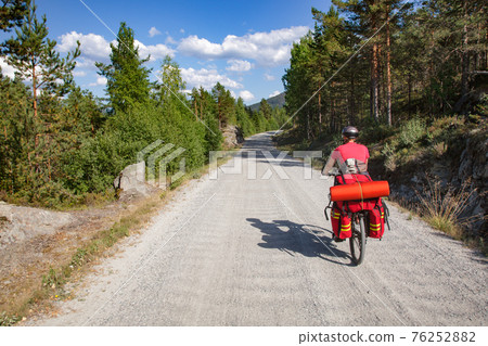 Traveling cyclist on cycle route in Southern Norway Traveling cyclist on cycle route in Southern Norway 76252882