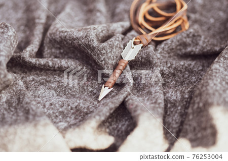 Pendant arrow necklace silver color shoot in a sunny day outside closeup. Selective Focus 76253004