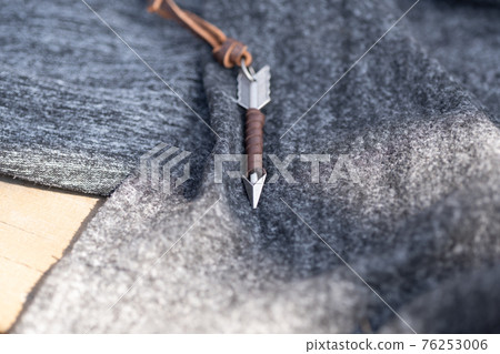 Pendant arrow necklace silver color shoot in a sunny day outside closeup. Selective Focus 76253006
