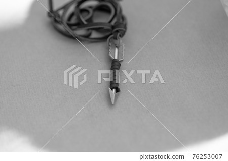 Pendant arrow necklace silver color shoot in a sunny day outside closeup. Selective Focus Pendant arrow necklace silver color shoot in a sunny day outside closeup. Selective Focus 76253007