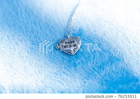 Pendant Best Friend heart necklace shoot outside in a summer day closeup. Selective Focus Pendant Best Friend heart necklace shoot outside in a summer day closeup. Selective Focus 76253011