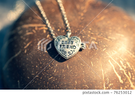 Pendant Best Friend heart necklace shoot outside in a summer day closeup. Selective Focus Pendant Best Friend heart necklace shoot outside in a summer day closeup. Selective Focus 76253012