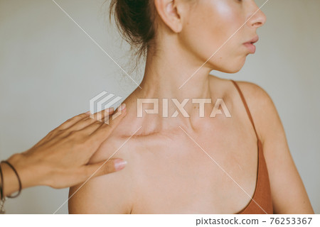 Female hands gently touch the young attractive brunette woman. Female hands gently touch the young attractive brunette woman. 76253367