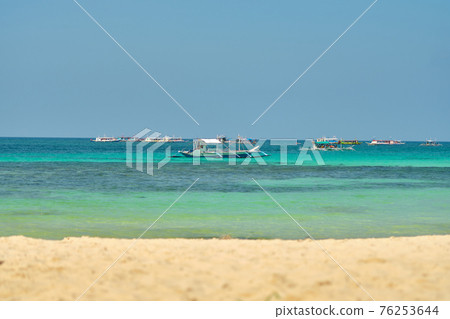 Empty White beach of Boracay island in the daytime. No Chinese tourists because of the coronavirus. Boats in the sea carry tourists. 76253644