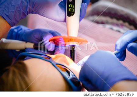 Little girl receiving dental filling procedure in pediatric dental clinic Little girl receiving dental filling procedure in pediatric dental clinic 76253959
