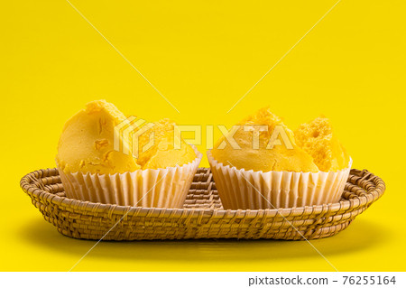 Side view of egg yolk threads yellow cotton candy cake in bamboo tray. Side view of egg yolk threads yellow cotton candy cake in bamboo tray. 76255164