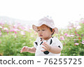 Young little cute asian girl playing in cosmos flower field in spring or summer season. 76255725