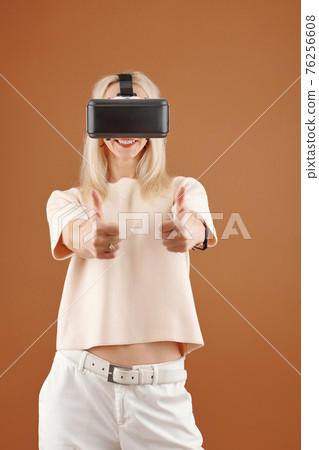 Excited woman in VR glasses 76256608