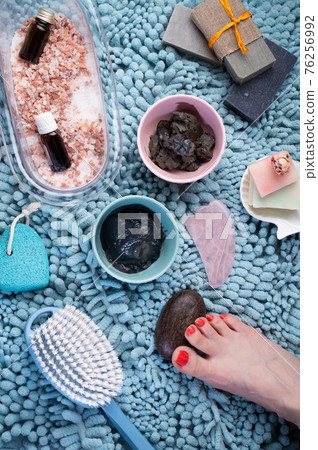 natural  healing  spa set with salt, healing mud and soap on blue bath mat. flay lay 76256992