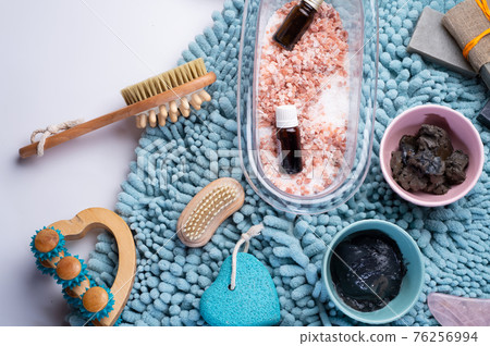 natural  healing  spa set with salt, healing mud and soap on blue bath mat. flay lay 76256994