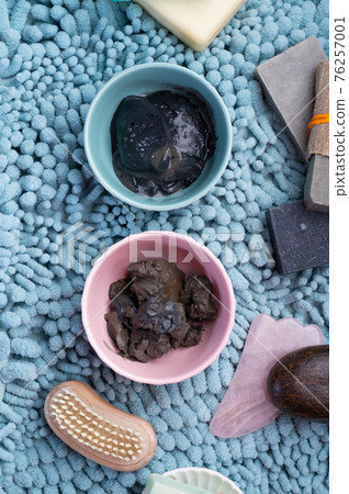 natural  healing  spa set with salt, healing mud and soap on blue bath mat. flay lay natural  healing  spa set with salt, healing mud and soap on blue bath mat. flay lay 76257001