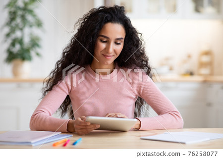 Modern Technologies Concept. Portrait Of Smiling Woman Using Digital Tablet In Kitchen Modern Technologies Concept. Portrait Of Smiling Woman Using Digital Tablet In Kitchen 76258077