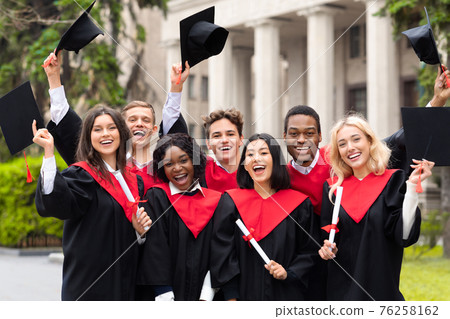 Joyful multiethnic students with diplomas celebrating graduation 76258162