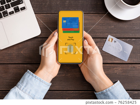 Woman's hands holding using cell phone with credit card Woman's hands holding using cell phone with credit card 76258425