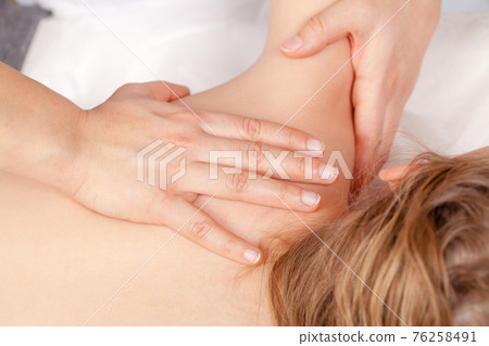Tween girl receiving osteopathic treatment or medical massage of her shoulder Tween girl receiving osteopathic treatment or medical massage of her shoulder 76258491
