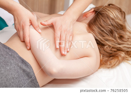 Patient receiving osteopathic treatment or medical massage of arm and shoulder blade Patient receiving osteopathic treatment or medical massage of arm and shoulder blade 76258505