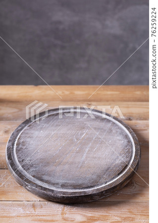 Pizza or bread cutting board and scattered wheat flour powder for homemade baking on wooden table Pizza or bread cutting board and scattered wheat flour powder for homemade baking on wooden table 76259224