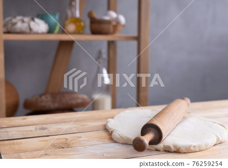 Wheat dough at flour powder and rolling pin on table for homemade bread cooking or baking Wheat dough at flour powder and rolling pin on table for homemade bread cooking or baking 76259254
