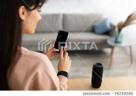 Back view of woman using phone with empty mockup screen Back view of woman using phone with empty mockup screen 76259380
