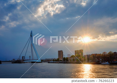 Rotterdam skyline cityscape with Erasmusbrug bridge over Nieuwe Maas in contre-jur on sunse, Netherlands. 76260223