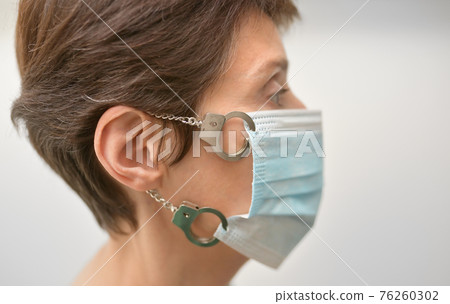 Woman With Medical Mask Locked with Handcuffs Woman With Medical Mask Locked with Handcuffs 76260302