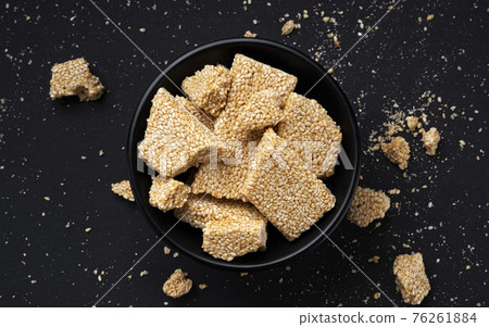 Sesame kozinaki on black background, top view Sesame kozinaki on black background, top view 76261884