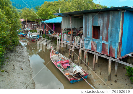 Fishermen's village in Asia. Boats near dilapidated houses on stilts 76262659
