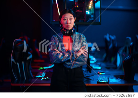 Young asian gamer in a headset poses for the camera with her arms folded 76262687