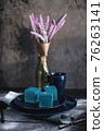 Blue cake filled with orange and tangerine in the shape of a cube. Rustic style. 76263141