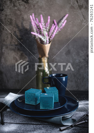 Blue cake filled with orange and tangerine in the shape of a cube. Rustic style. Blue cake filled with orange and tangerine in the shape of a cube. Rustic style. 76263141