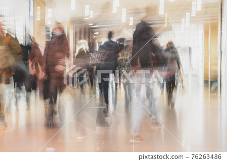 Blurred silhouettes of People Rushing in Shopping Mall. Abstract defocused Background Blurred silhouettes of People Rushing in Shopping Mall. Abstract defocused Background 76263486