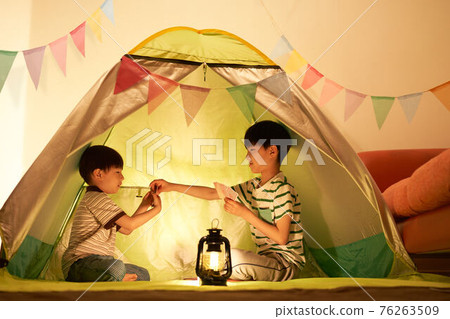 Boy playing in an indoor tent Boy playing in an indoor tent 76263509