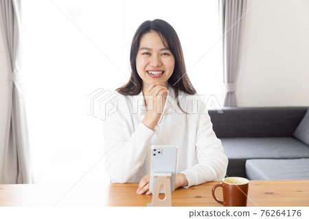 A young woman operating a smartphone A young woman operating a smartphone 76264176