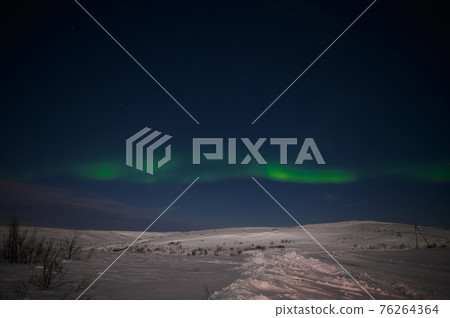 northern light on the silent field before sun rise. 76264364