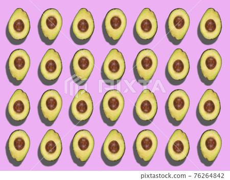 A colorful pattern of cut avocados spinning on a light violet background. Zenithal top view. A colorful pattern of cut avocados spinning on a light violet background. Zenithal top view. 76264842