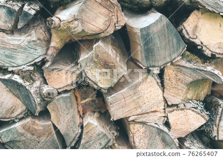 Old Firewood or fuelwood stacked by a wall. Texture woodpile 76265407